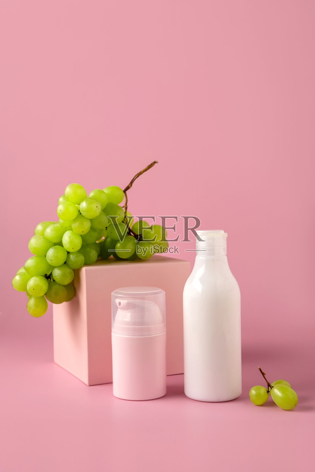 在领奖台上模拟一个用葡萄籽油做商标的瓶子。化妆品包装。护肤美容产品。照片摄影图片