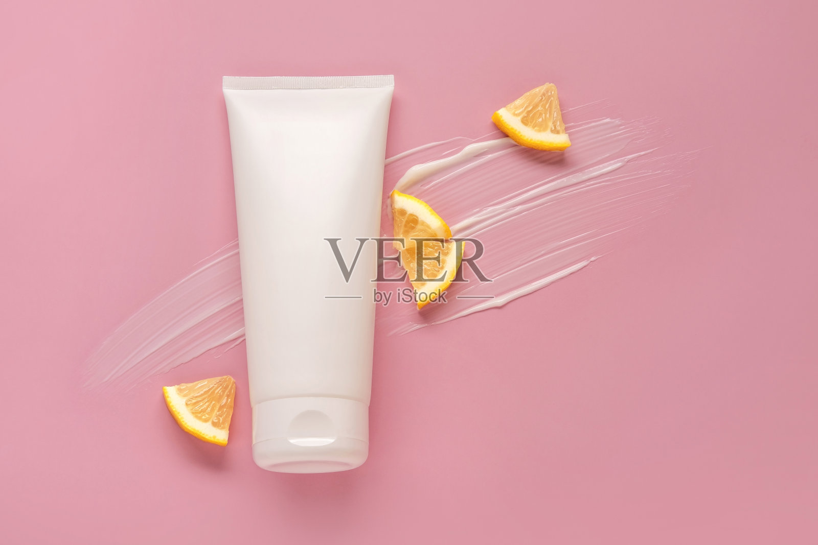 白色模拟瓶的品牌与柠檬片。化妆品概念与果酸。粉色背景上的化妆模型。照片摄影图片