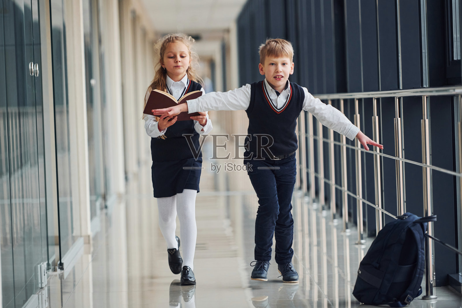 穿着校服的学生在走廊里。教育的概念照片摄影图片