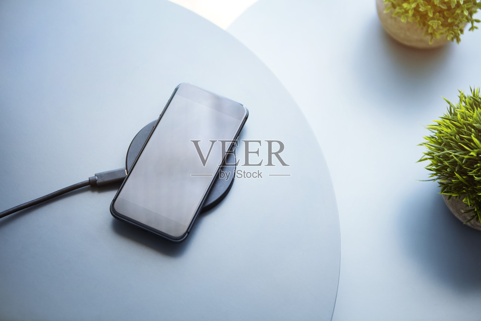 从上到下的视图使用无线充电的智能手机电池。照片摄影图片