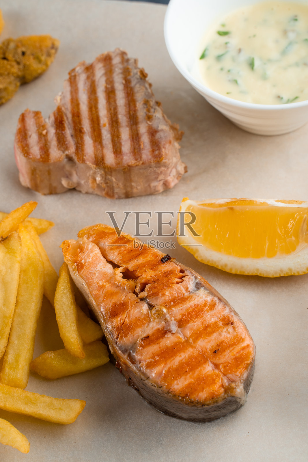 烧烤海鲜串与烤贻贝,金枪鱼,鲑鱼在木串上与白汁和柠檬照片摄影图片