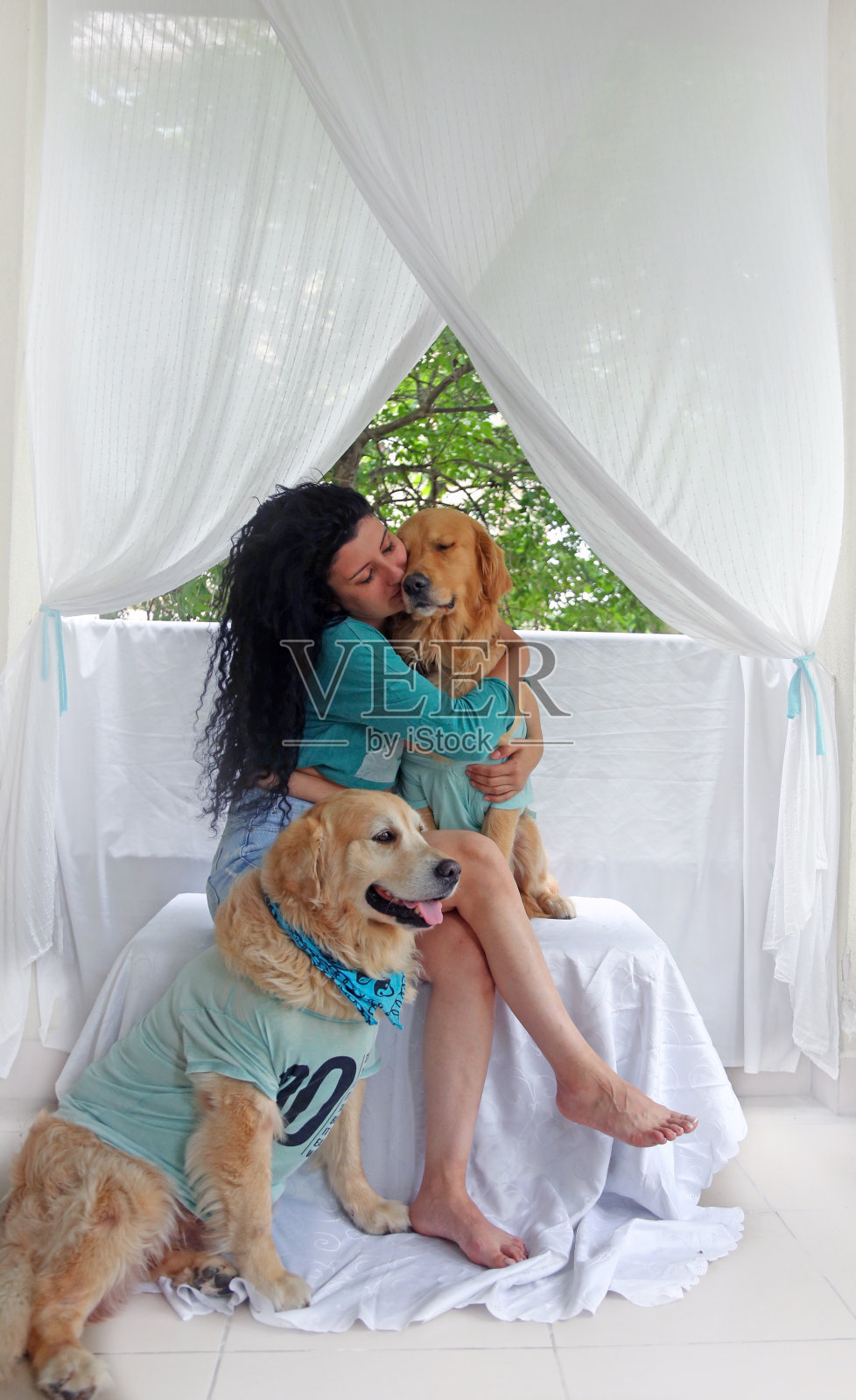 和两只狗在露台上享受假期的年轻漂亮女子照片摄影图片