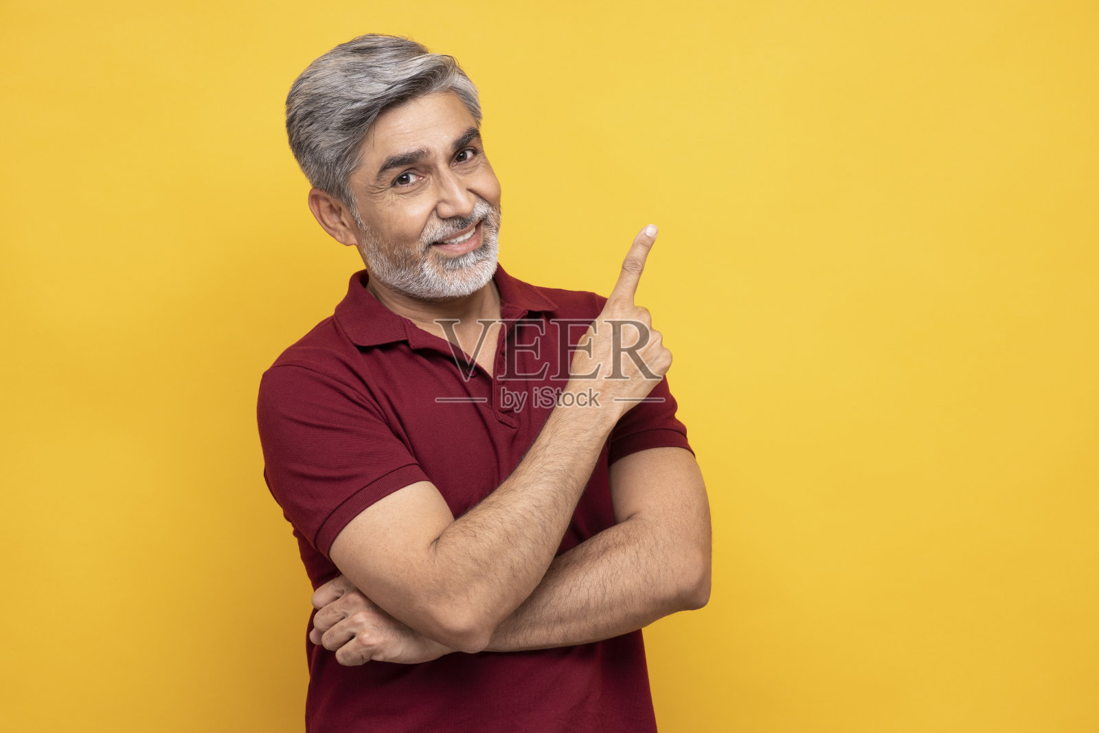 肖像英俊的成熟男子指与手指孤立在黄色背景:股票照片照片摄影图片