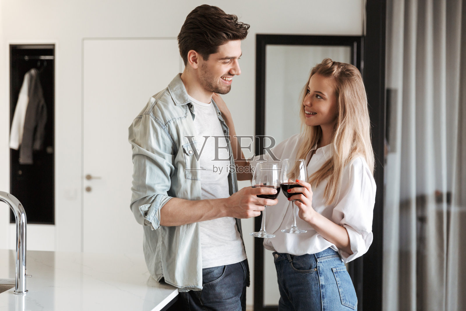 可爱恩爱的夫妇在家里室内喝酒。照片摄影图片