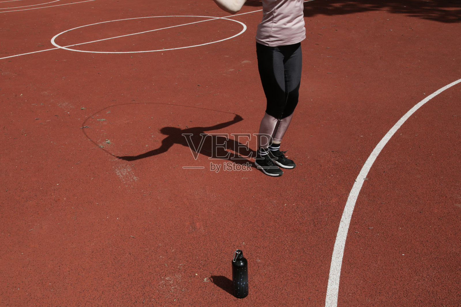 年轻女子在运动场上跳绳照片摄影图片