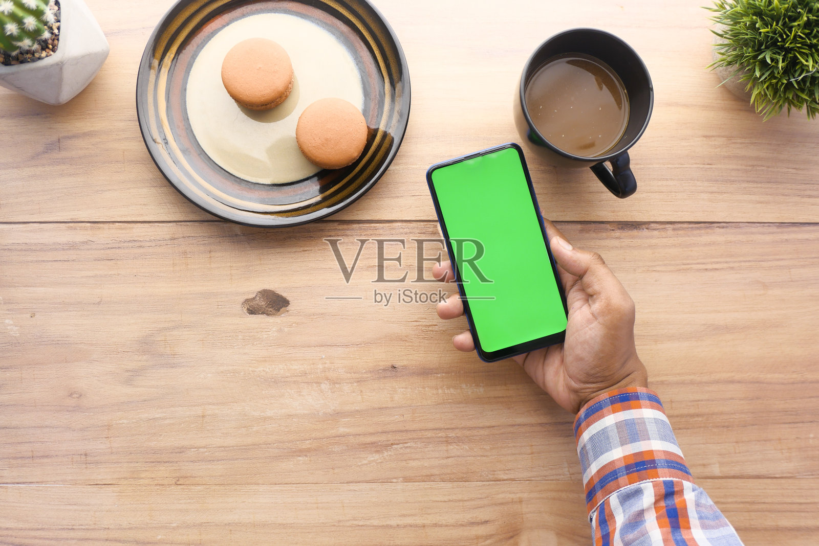 在办公桌上使用智能手机的男人手的俯视图照片摄影图片