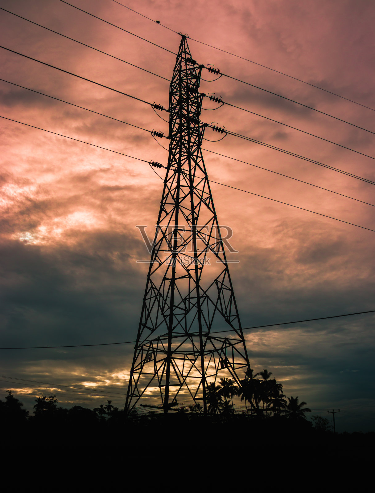 电线和高高的电线塔映衬着晚霞的背景。照片摄影图片