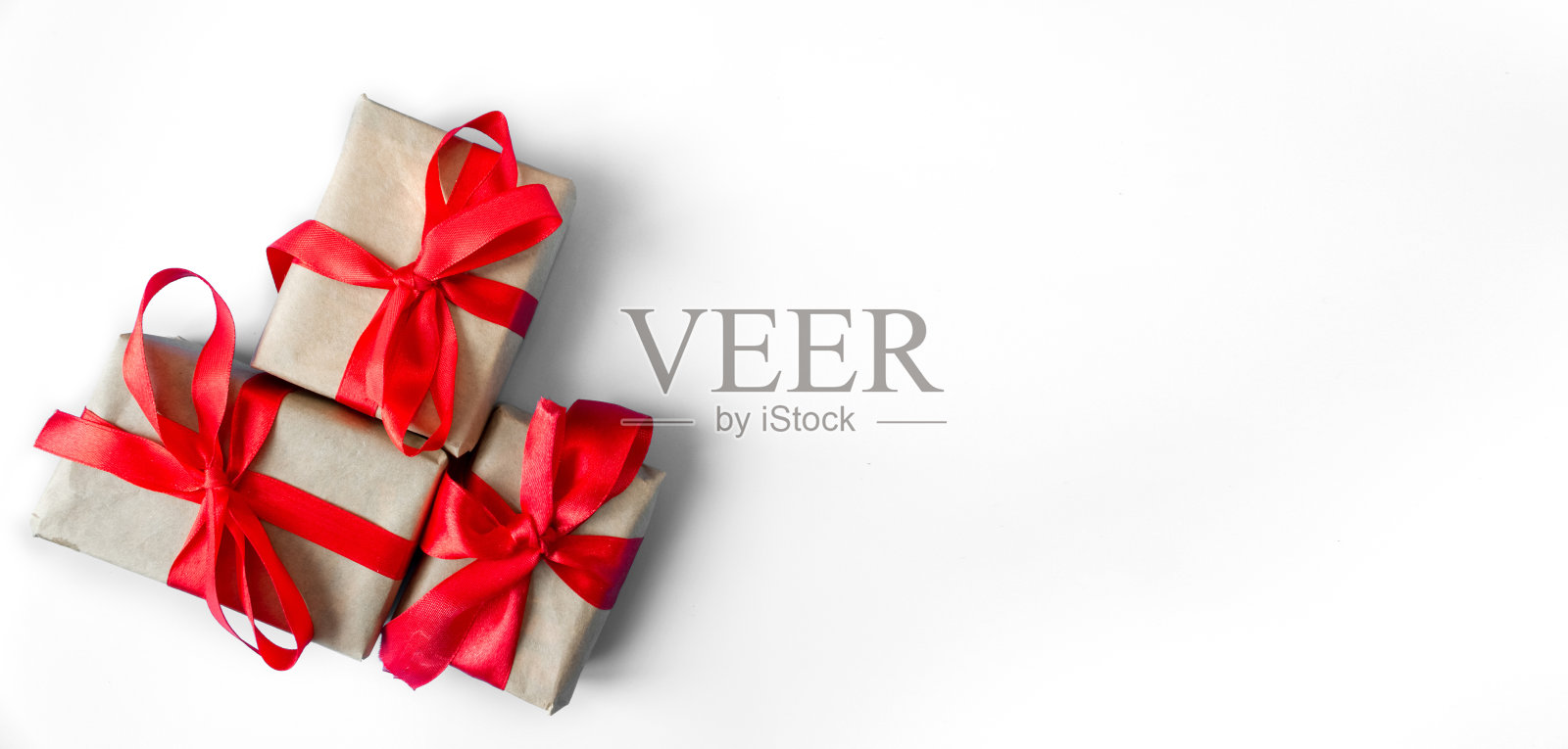 白色背景上有红色蝴蝶结的礼品盒。照片摄影图片