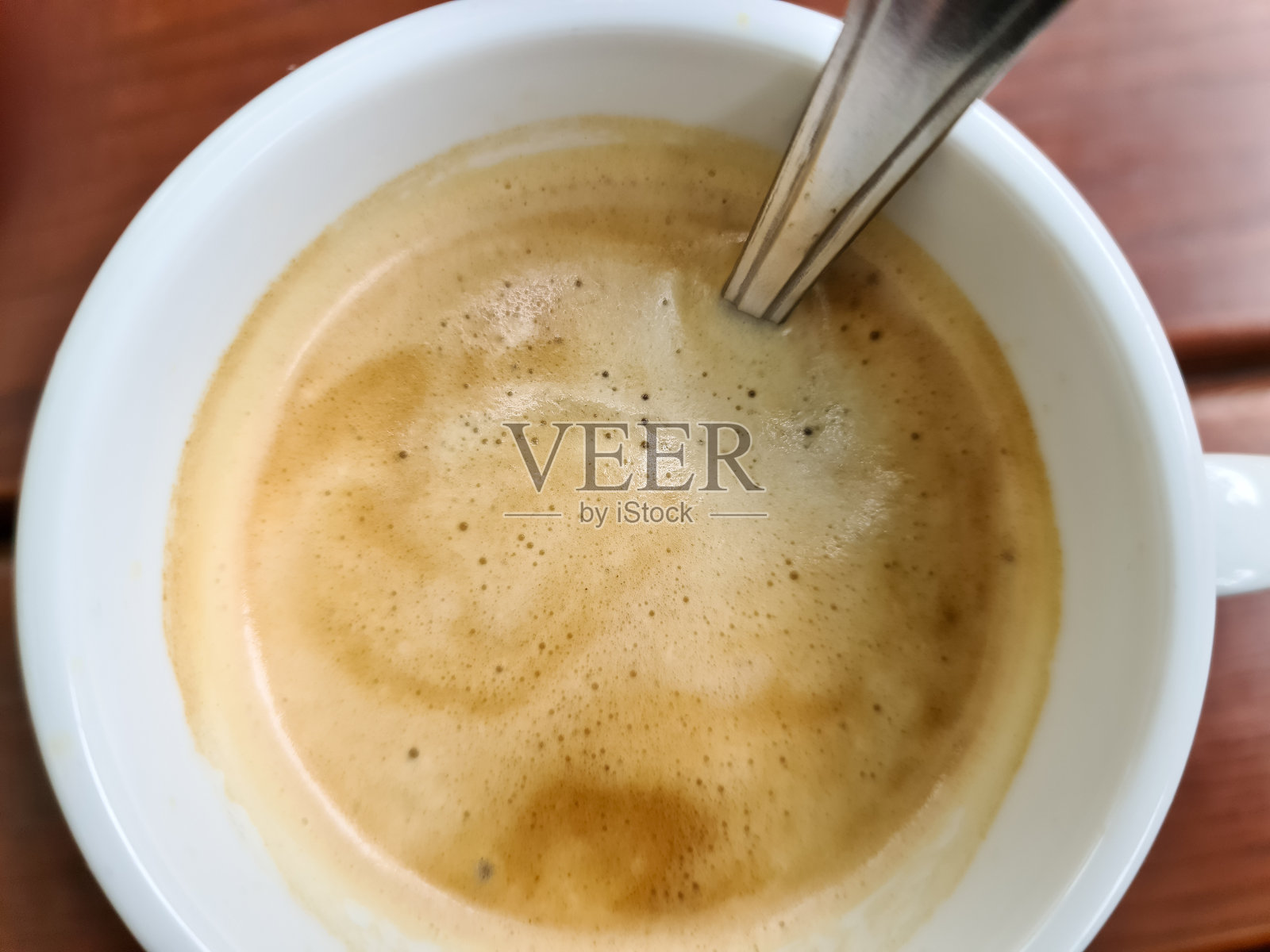 近距离观看在一个白色的咖啡表面,一个杯子在一个棕色的木制背景。照片摄影图片