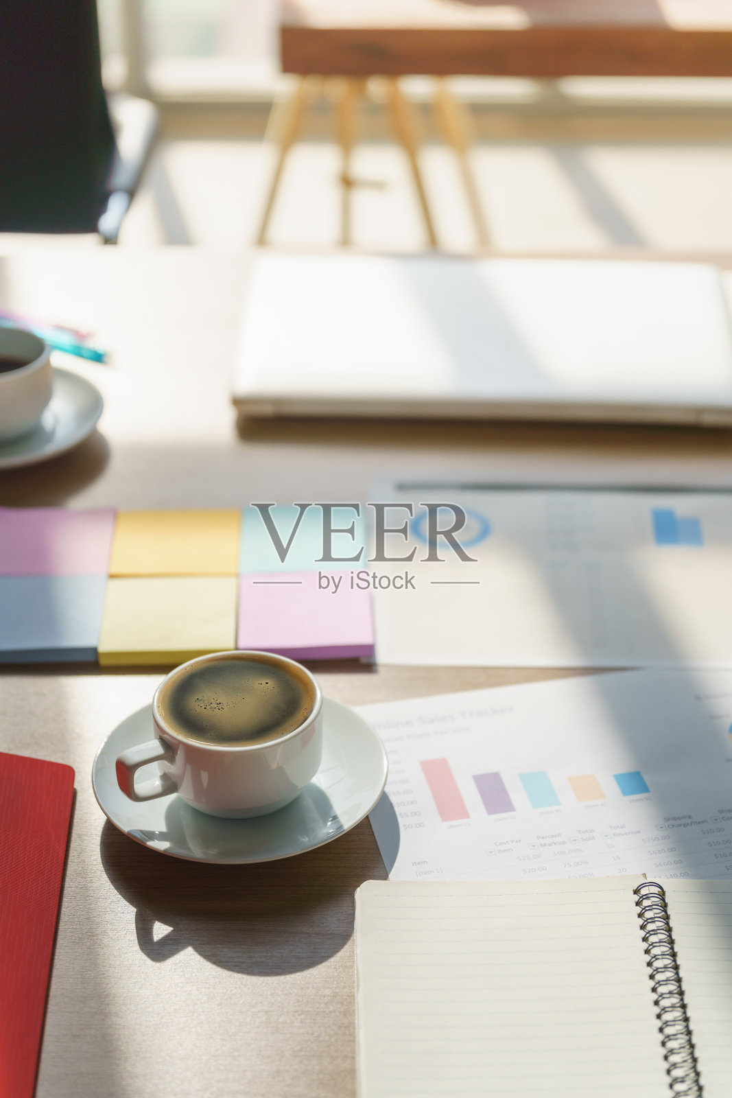 特写的白色杯热黑咖啡美式咖啡与图表文件和笔记本木制办公桌。照片摄影图片