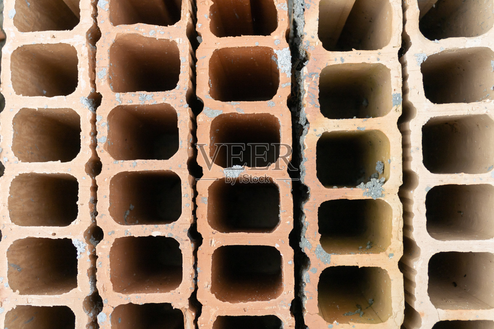 一套橙色的建筑砖内衬的方孔和不同的阴影。它们形成了一种有趣的纹理。用于建造房屋和建筑物。照片摄影图片