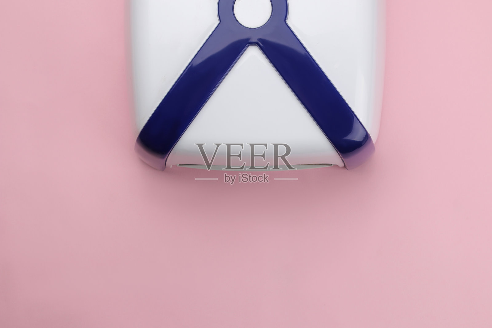 修指甲。紫外光灯在柔和的粉红色背景上。美甲配件和指甲工具。俯视图照片摄影图片