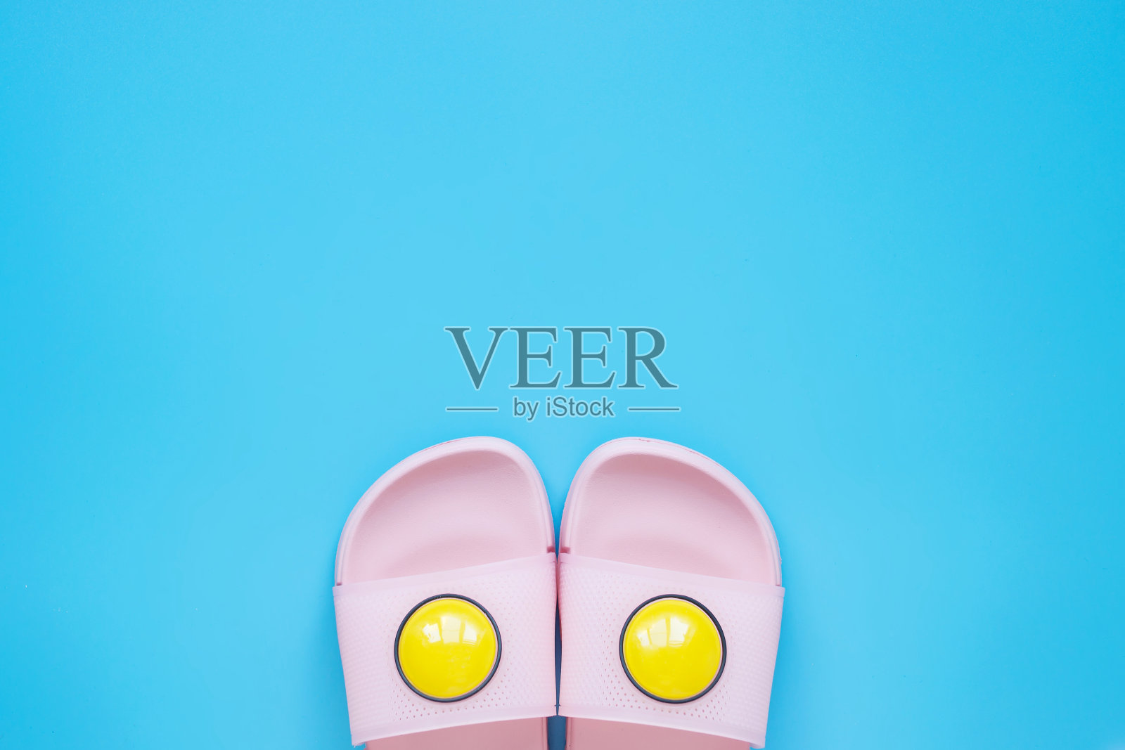 蓝色底色的粉色沙滩鞋。夏天,海滩度假和旅游的概念。夏天的背景。照片摄影图片