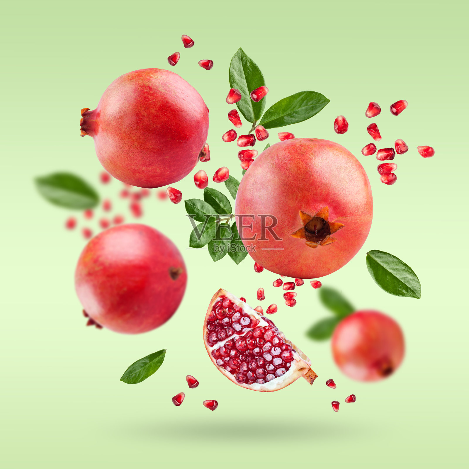 一个成熟的石榴带着种子和叶子在空中飞舞。背景以石榴果。照片摄影图片