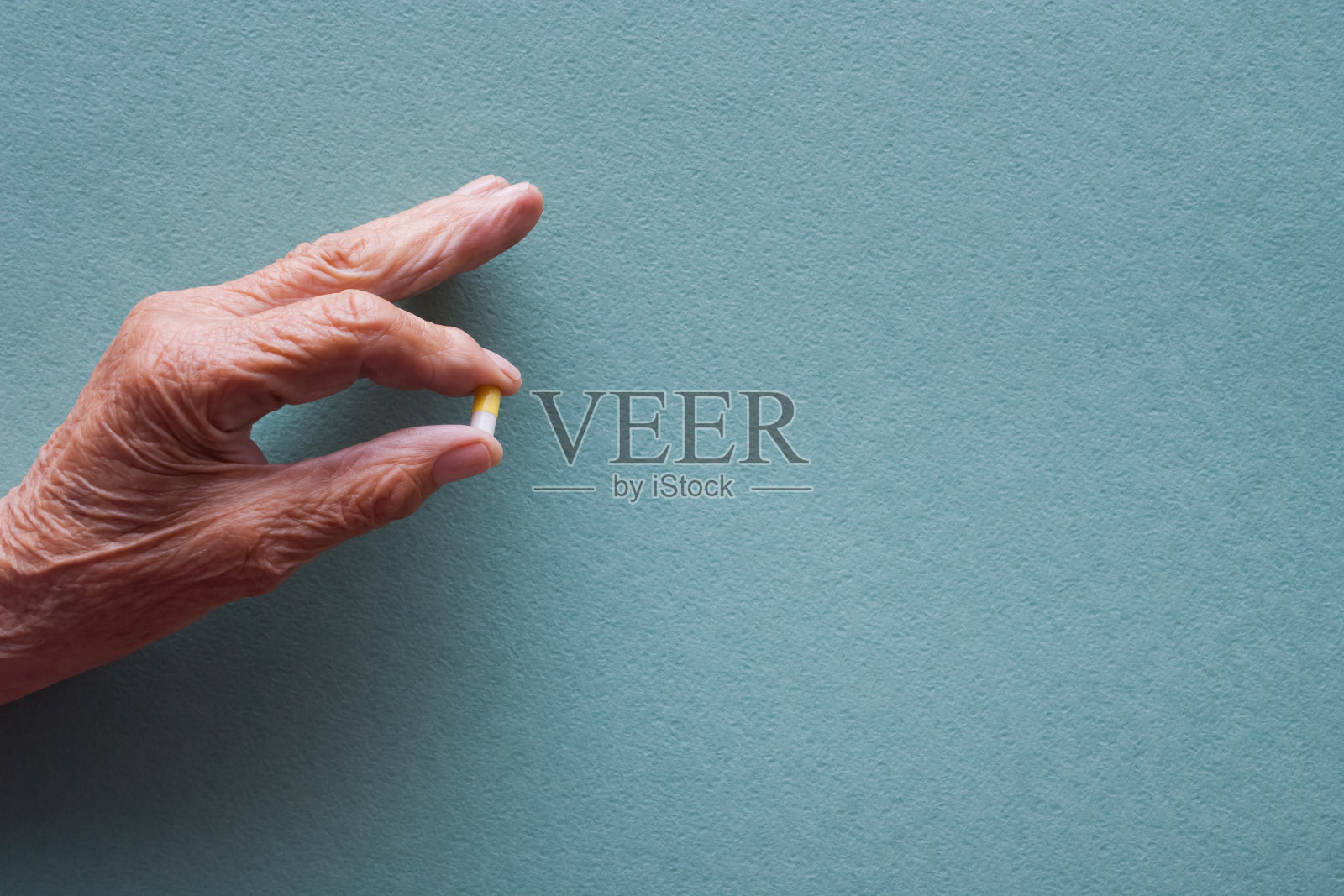 一个拿着药丸的老妇人的手。长寿的概念。老年疾病的治疗照片摄影图片