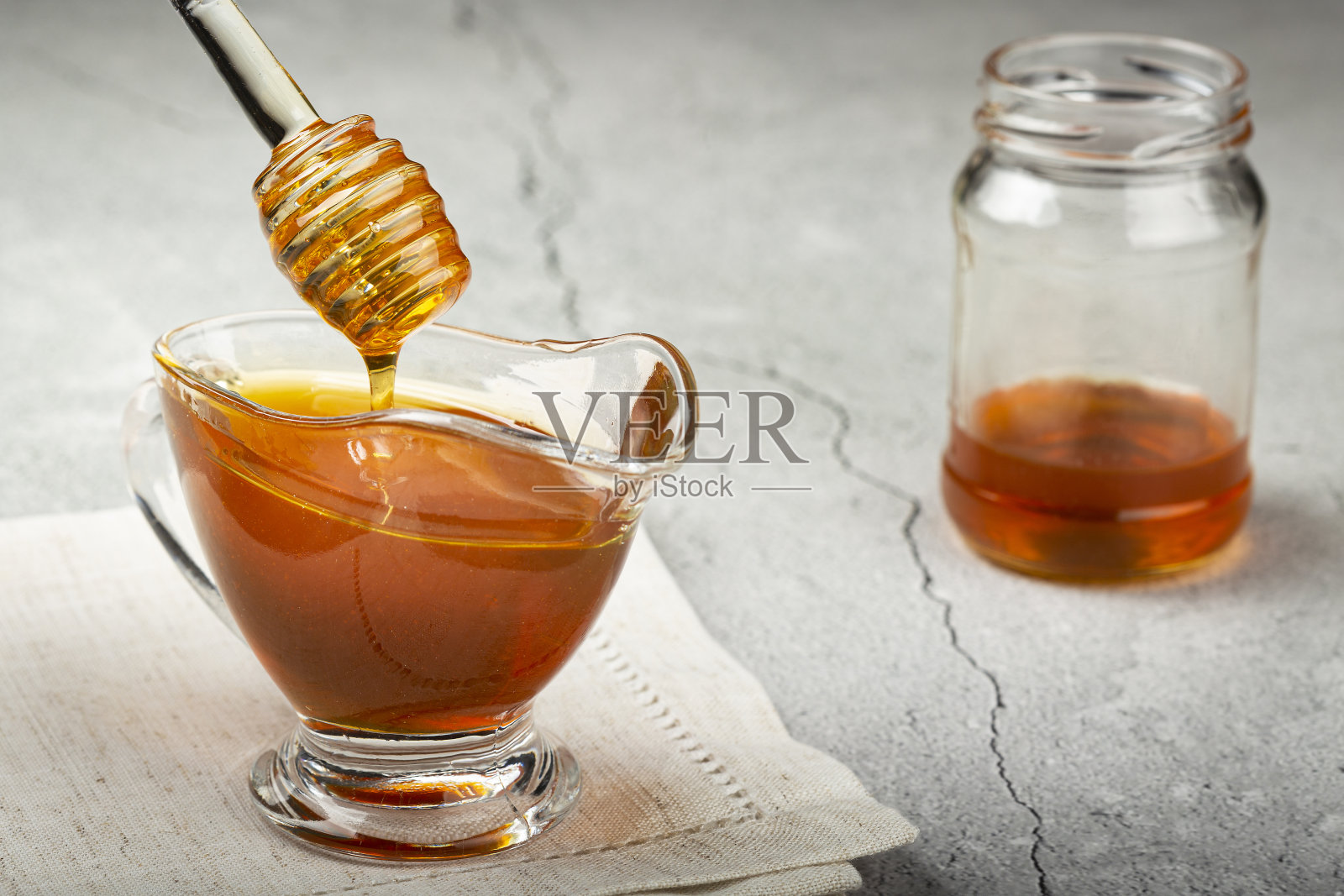 蜂蜜在玻璃碗在桌子上。照片摄影图片