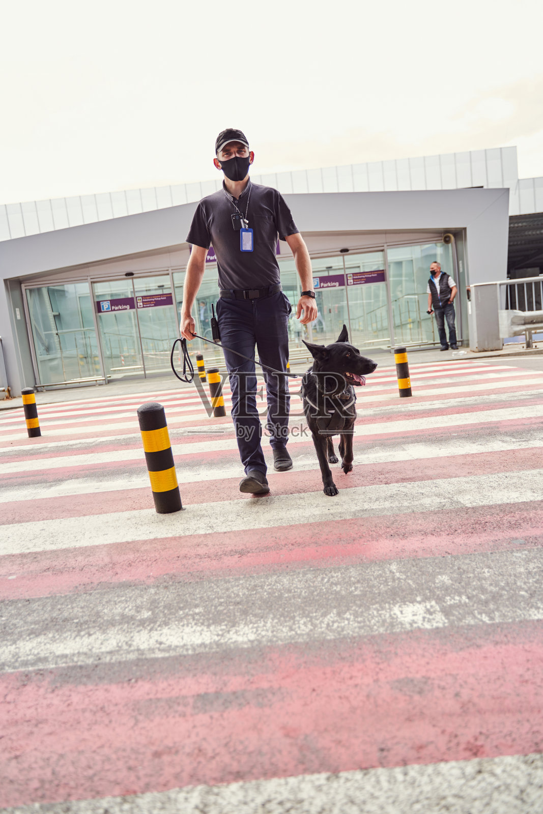 保安带着警犬在机场过马路照片摄影图片