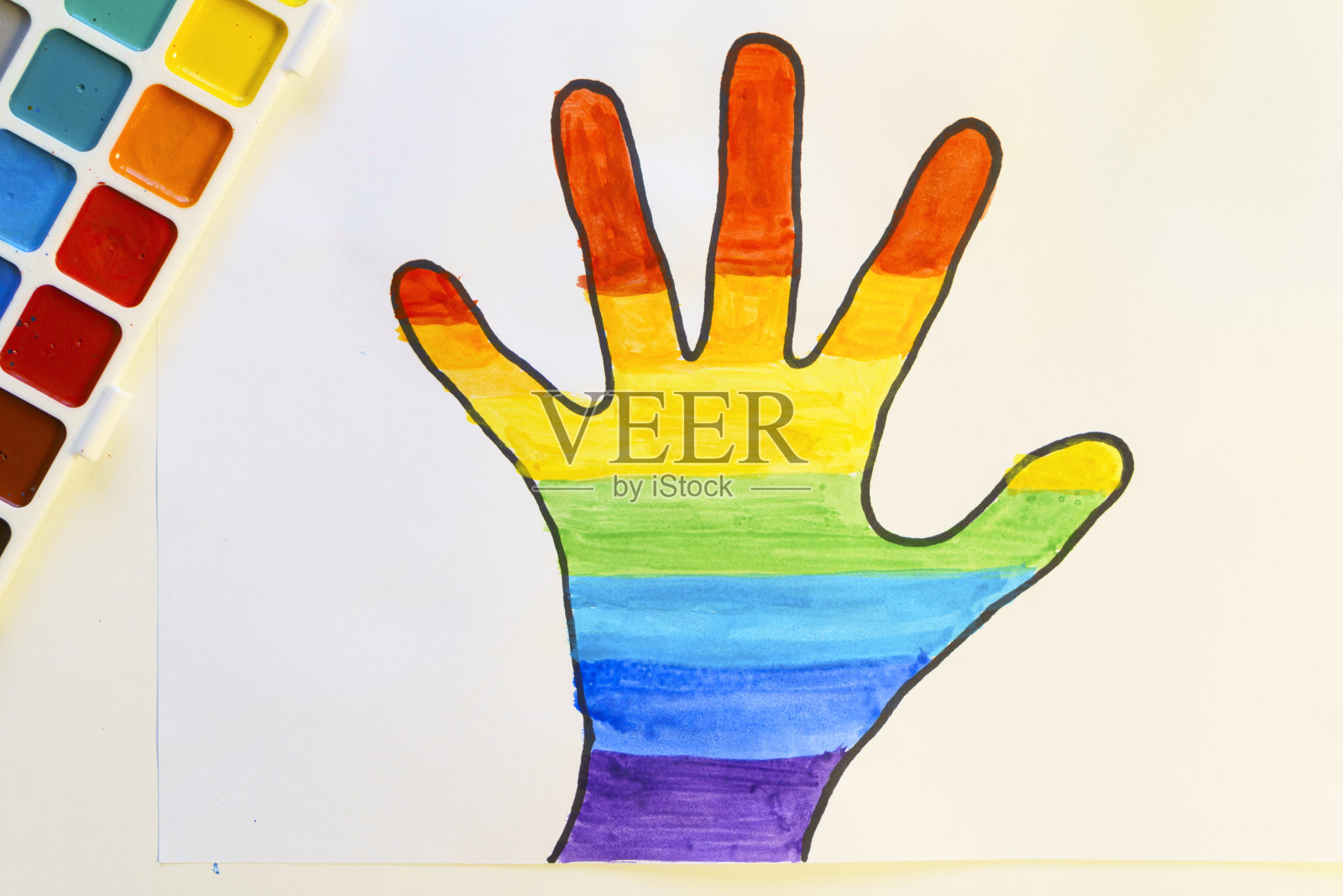 人的手画在纸上,用彩虹的各种颜色的水彩画照片摄影图片