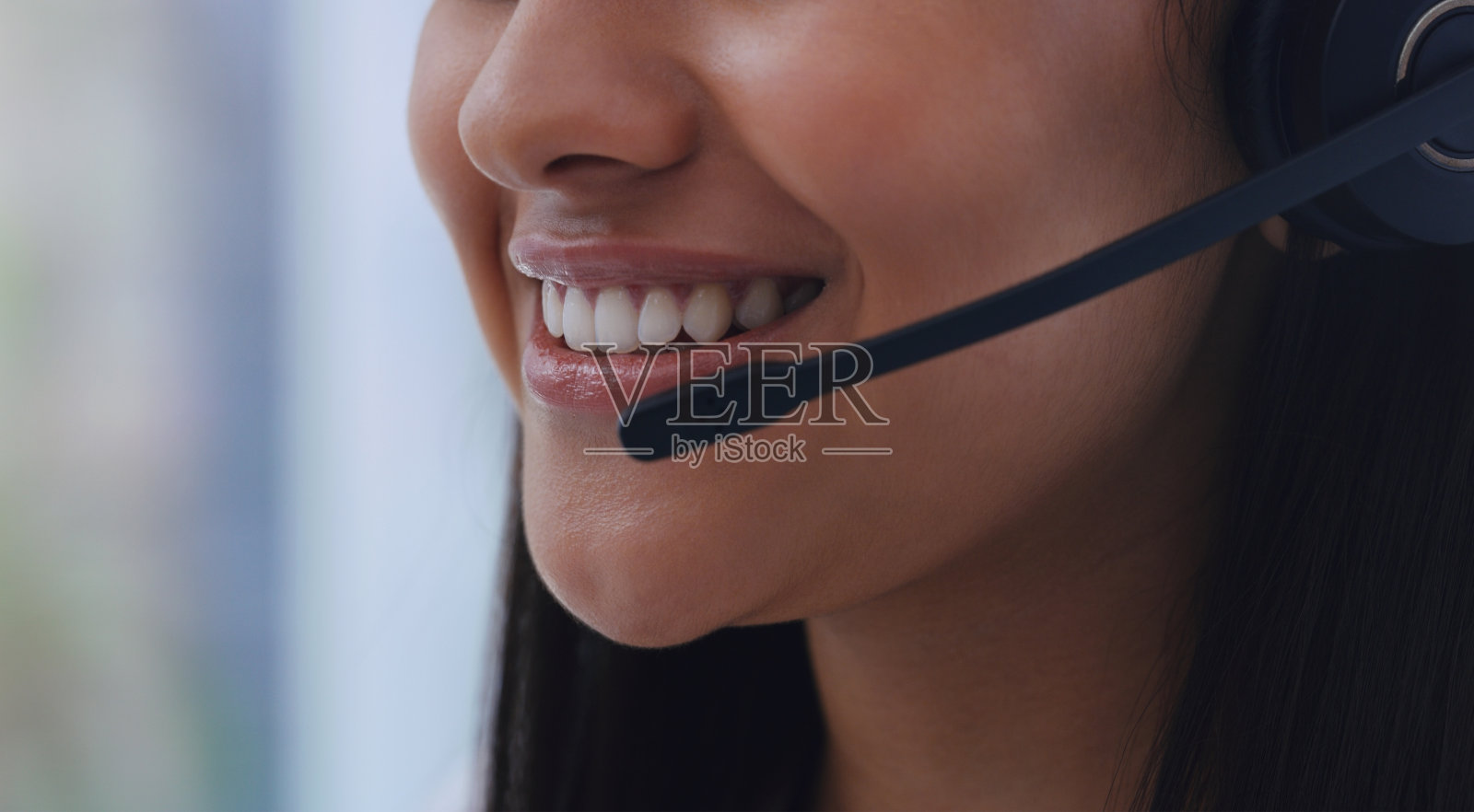 近距离拍摄一个不认识的女商人戴着耳机在办公室照片摄影图片