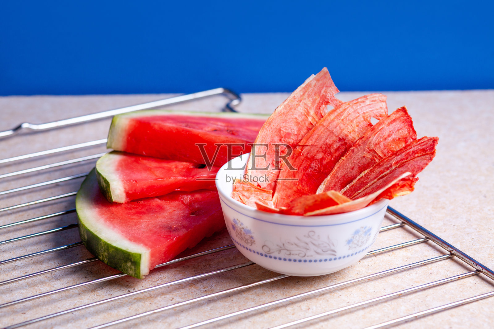 冬季用品:干西瓜片和新鲜的西瓜片,在明亮的背景和网格照片摄影图片