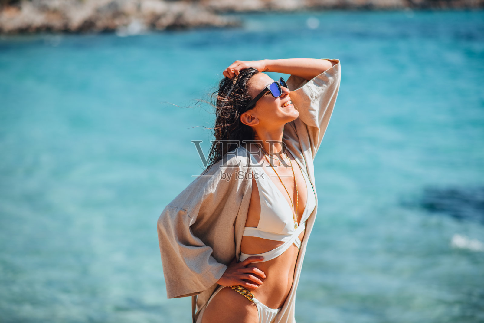 快乐的女人在沙滩上摆比基尼姿势照片摄影图片