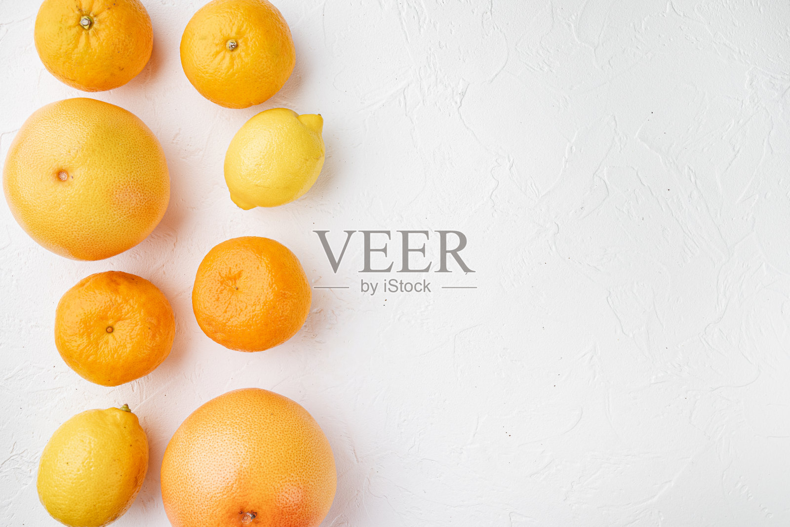 新鲜的混合柑橘类水果,白色的石桌背景,平铺俯视图,有文字拷贝空间照片摄影图片