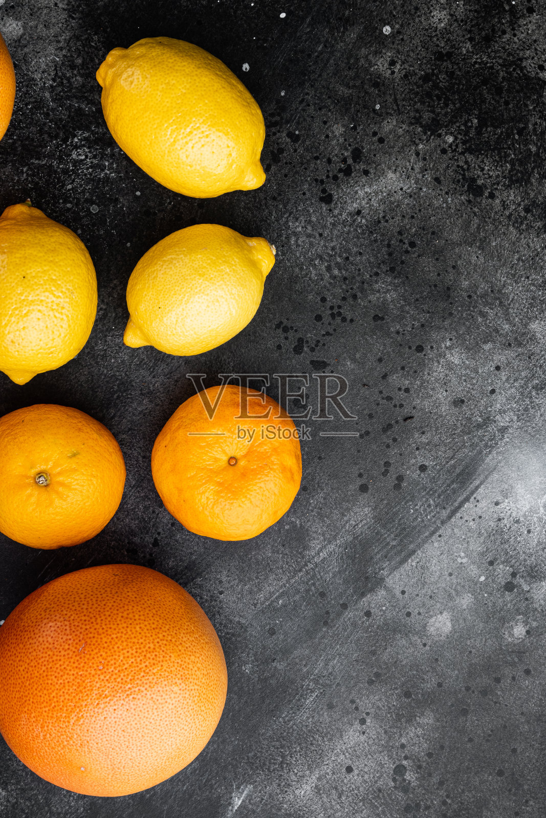 柑橘类水果,以黑色的深色石桌为背景,俯视图平铺,有文字拷贝空间照片摄影图片