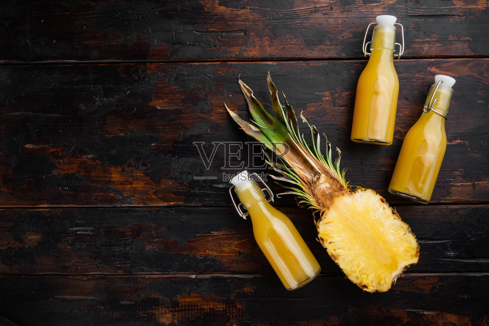 新鲜成熟的菠萝和一杯果汁,在旧的深色木桌背景上,俯视图平铺,与文本复制空间照片摄影图片