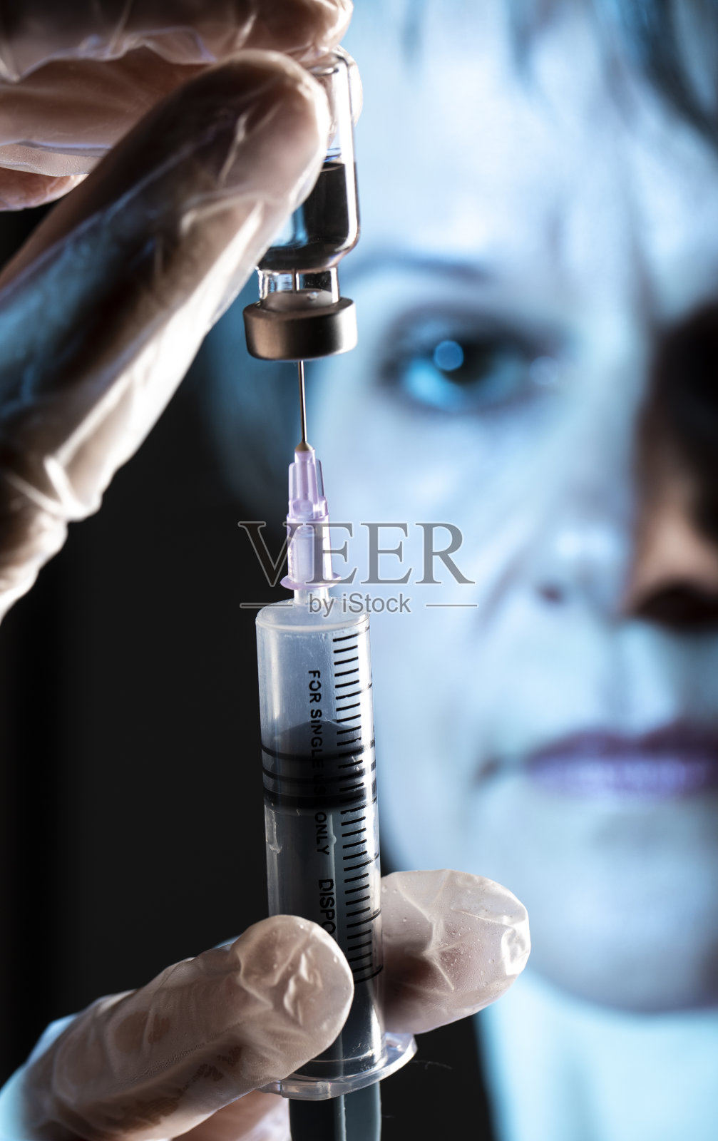 用注射器从疫苗瓶中抽取药液的手照片摄影图片