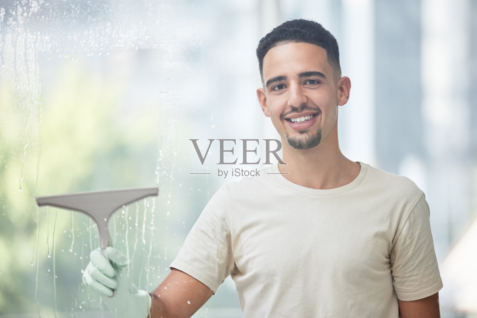 一个年轻人在家里擦玻璃窗的照片照片摄影图片