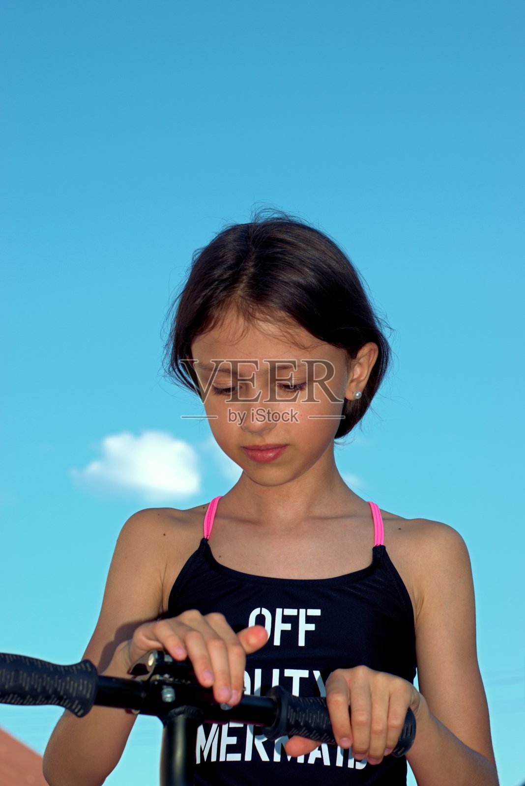 女孩骑着踏板车在房子附近走照片摄影图片