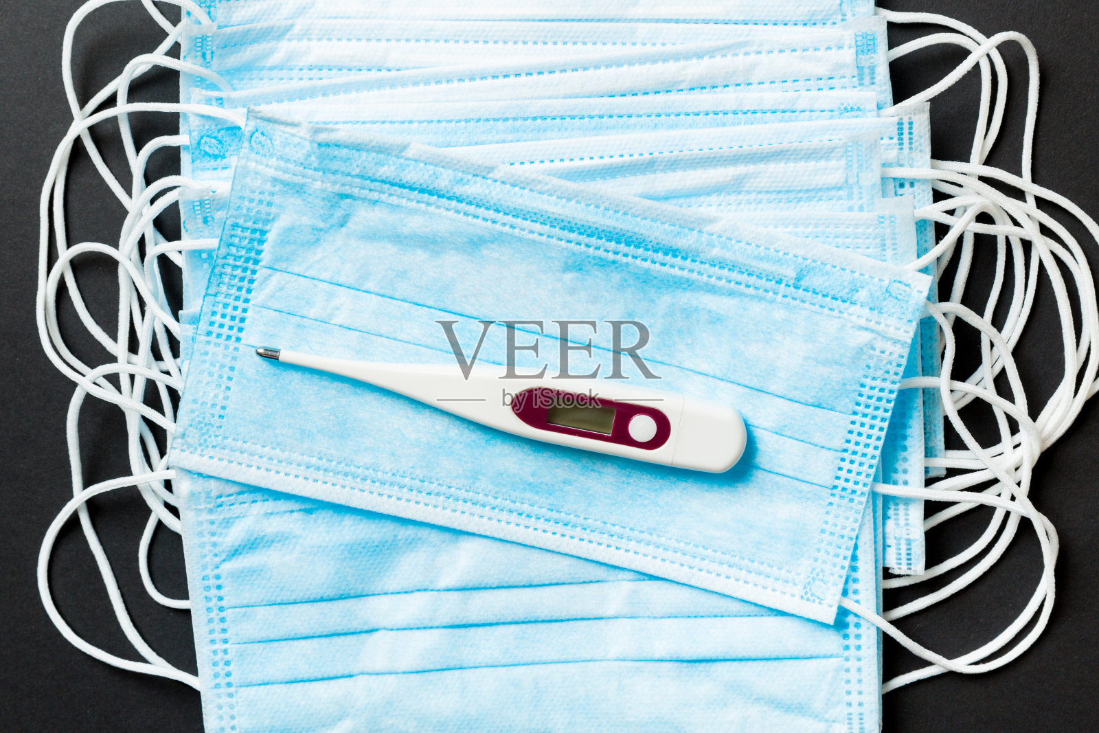 医用防护口罩的流行背景和彩色背景上的温度计。世界隔离的概念照片摄影图片