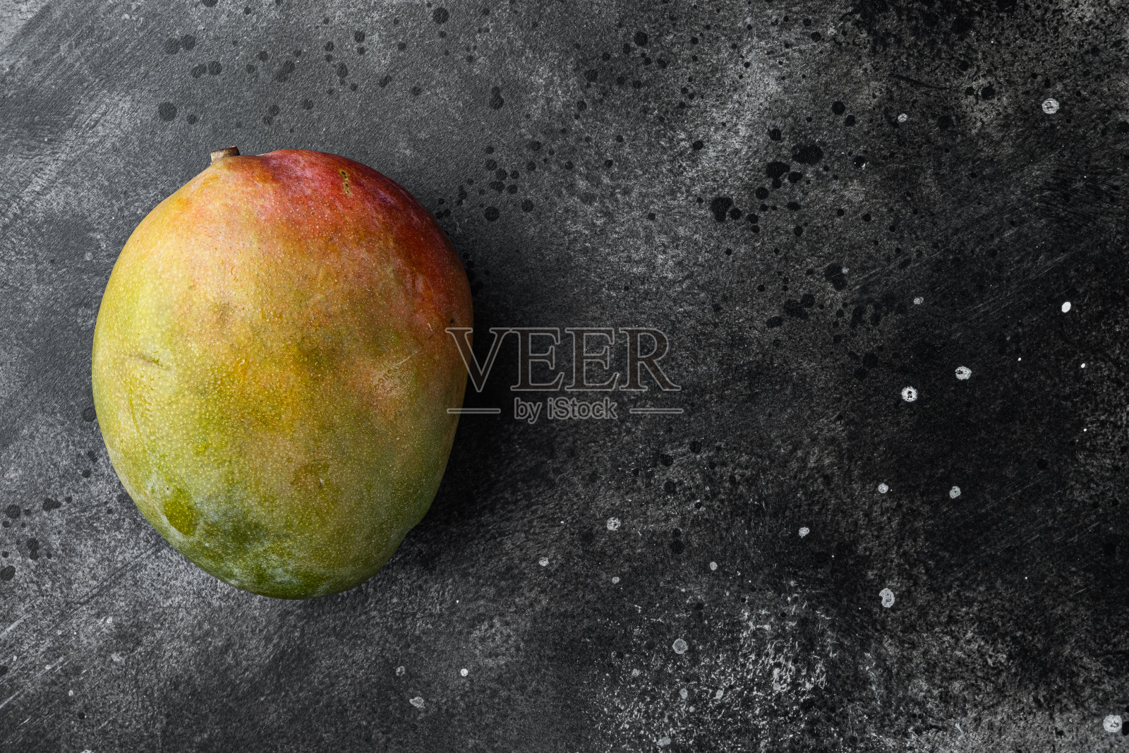 熟透的芒果果,以黑色的深色石桌为背景,俯视图平铺,有文字复制空间照片摄影图片