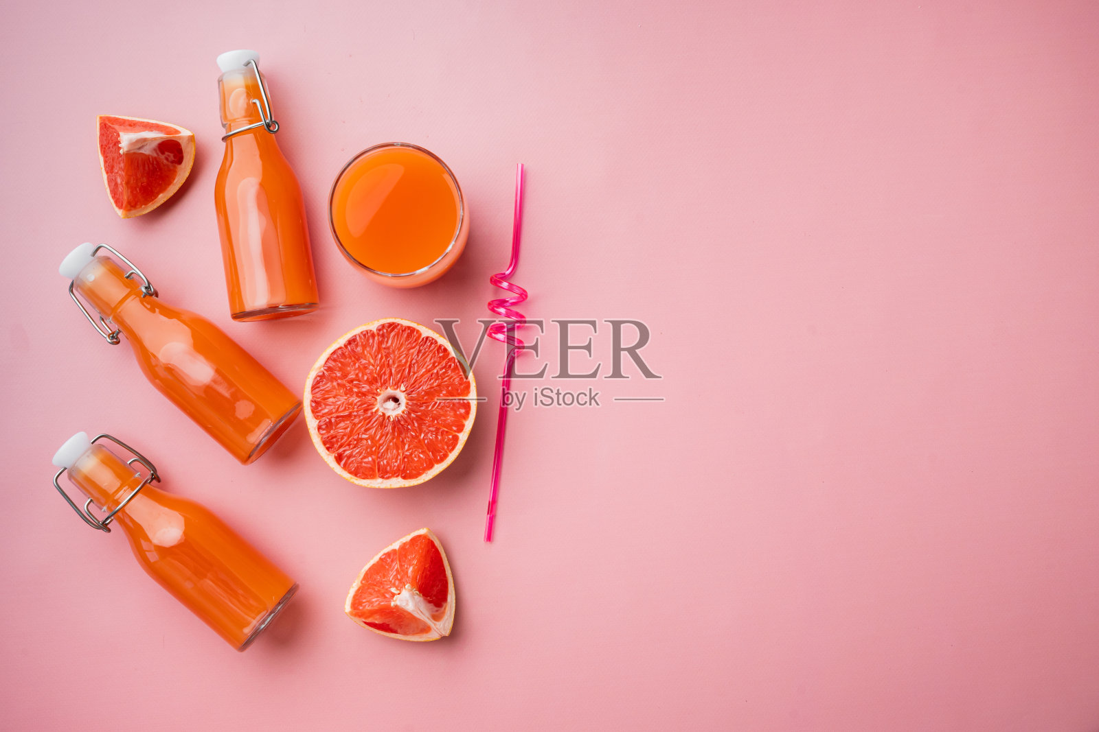 新鲜的有机粉红葡萄柚汁,在粉红色纹理的夏季背景,俯视图平躺,与文本复制空间照片摄影图片