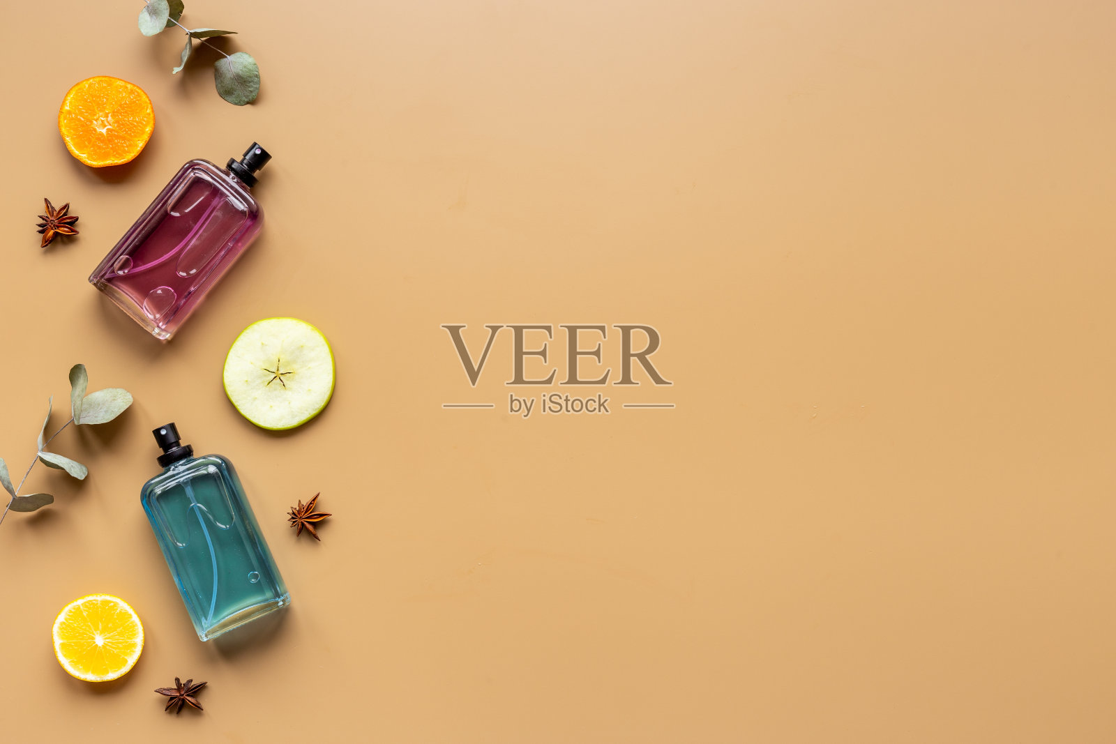 装着花、叶和水果的香水瓶。俯视照片摄影图片