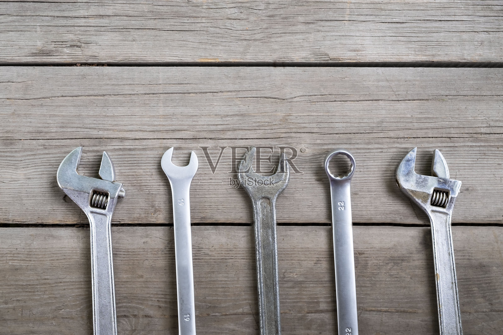 扳手和可调节扳手在一个旧的木制背景上。俯视图照片摄影图片