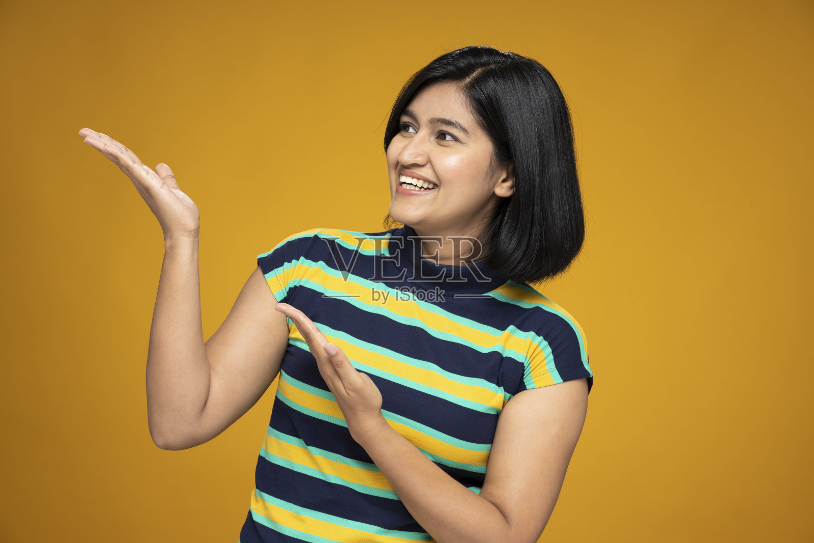 年轻妇女的肖像在短头发站孤立的黄色背景:股票照片照片摄影图片