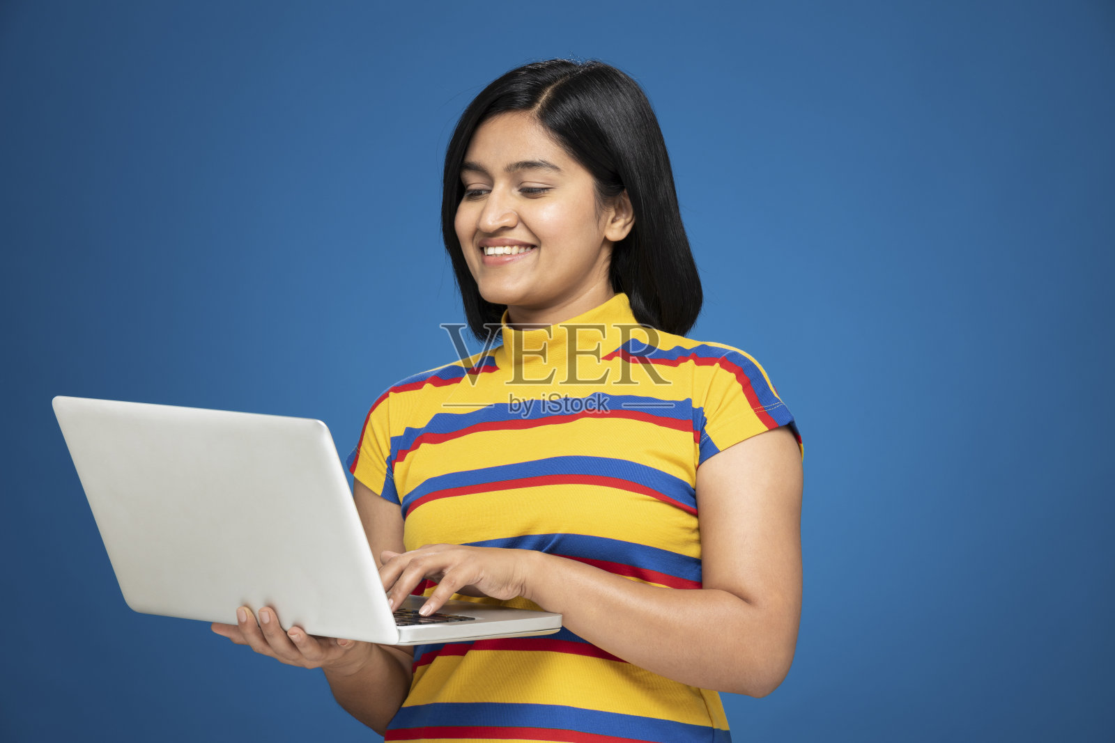 年轻女性的肖像在短头发站孤立的蓝色背景:库存照片照片摄影图片