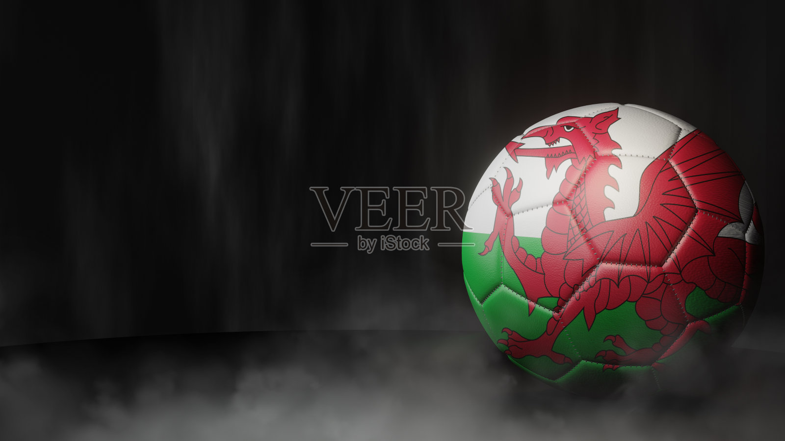 在一个深色抽象背景上的旗帜颜色的足球。威尔士。照片摄影图片