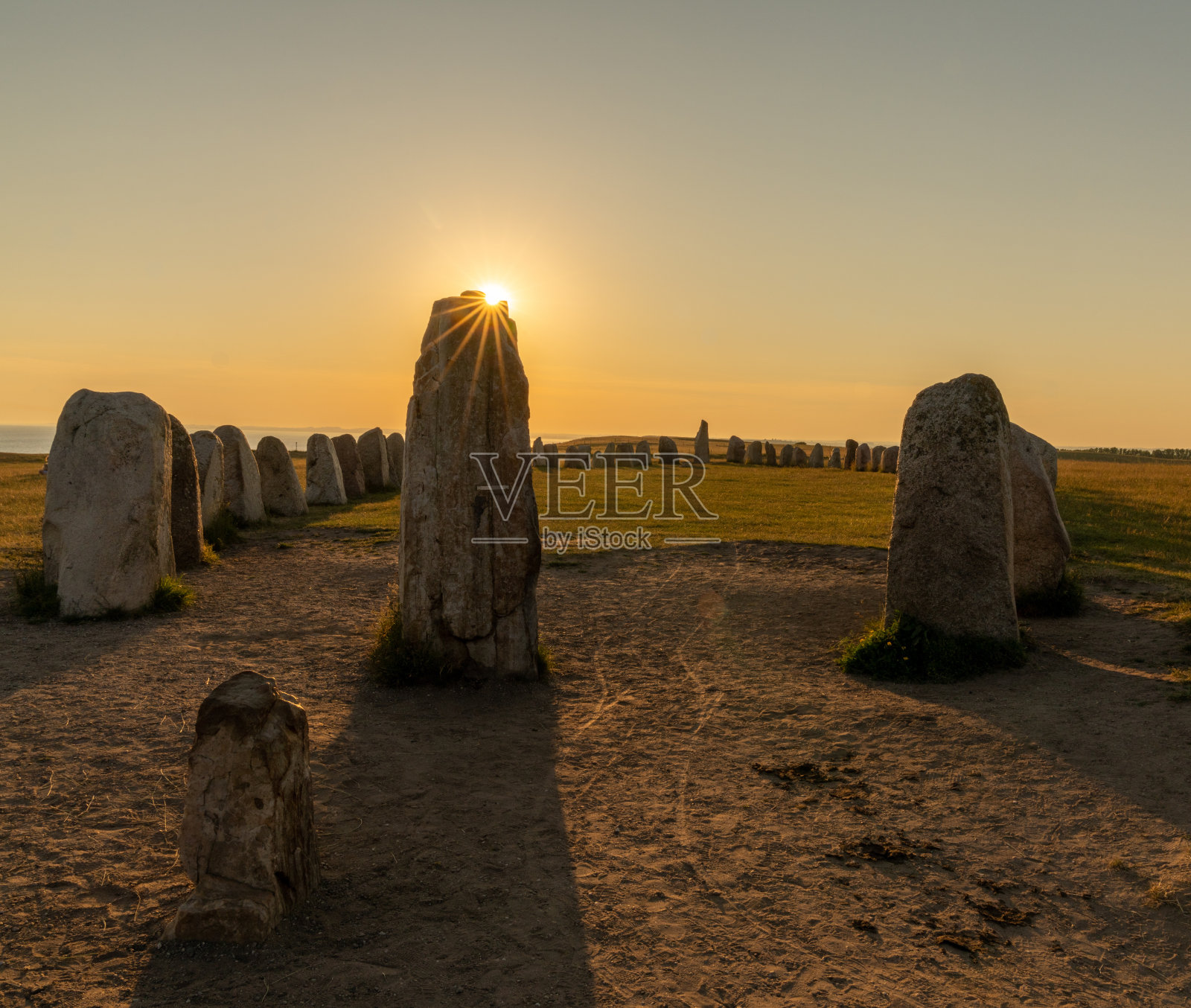 史前的阿莱斯·斯坦纳号船在日落时与一颗太阳星一起落在瑞典南部海岸照片摄影图片