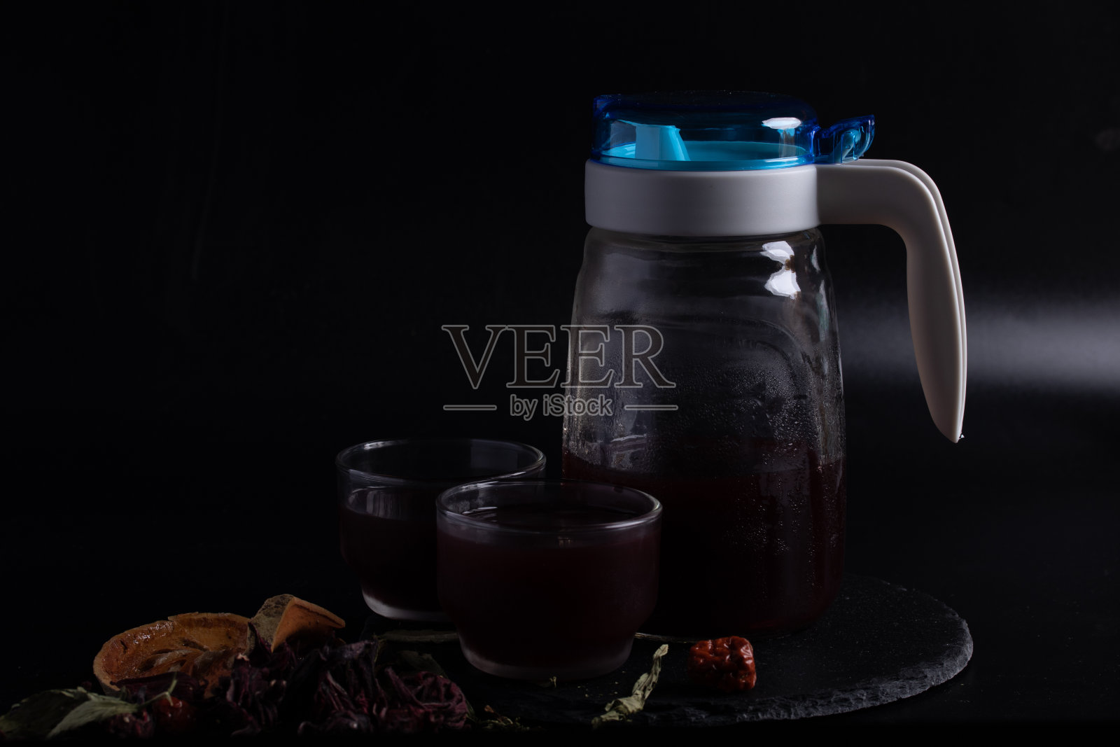 草药汁与秋葵,百乐,甜叶菊混合在一个透明的玻璃罐中,背景为黑色。照片摄影图片