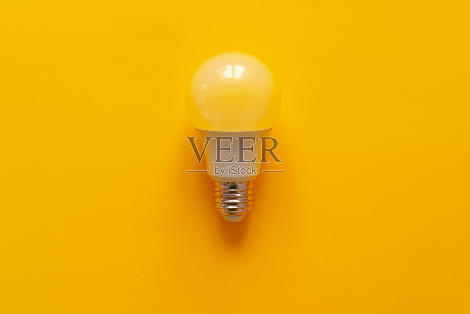 灯泡上的黄色纸背景俯视图照片摄影图片