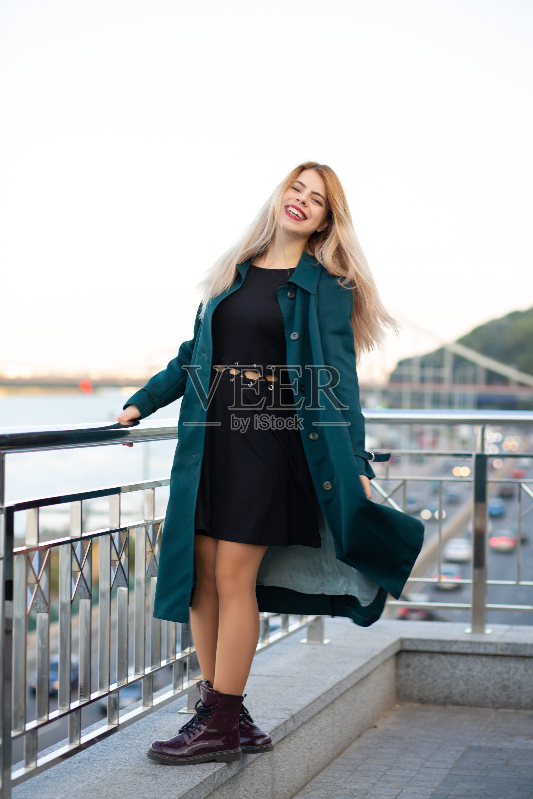 穿着外套的快乐的时髦女人在城市广场玩得很开心照片摄影图片