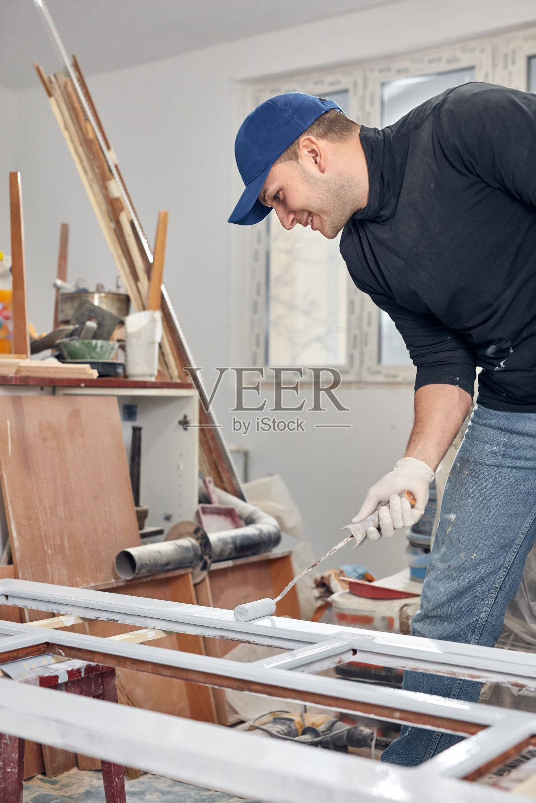 年轻的成年人画在自己动手做的预算装修他的新家公寓。照片摄影图片