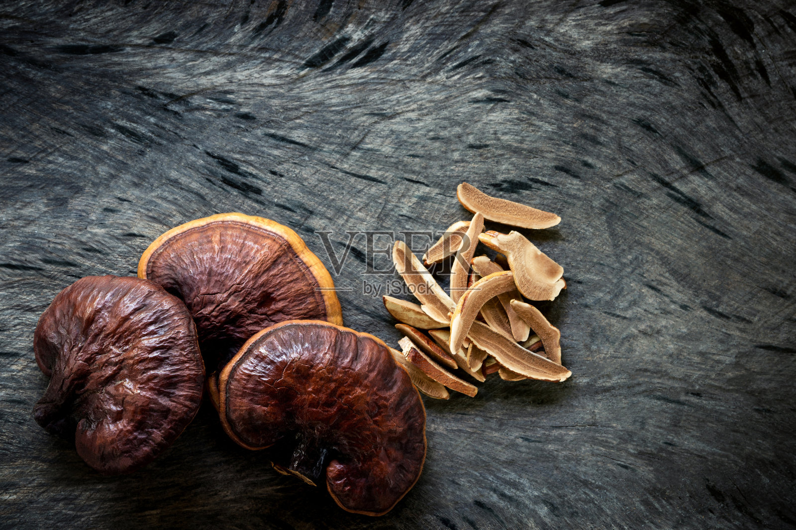 新鲜灵芝蘑菇放在深色木地板上。照片摄影图片