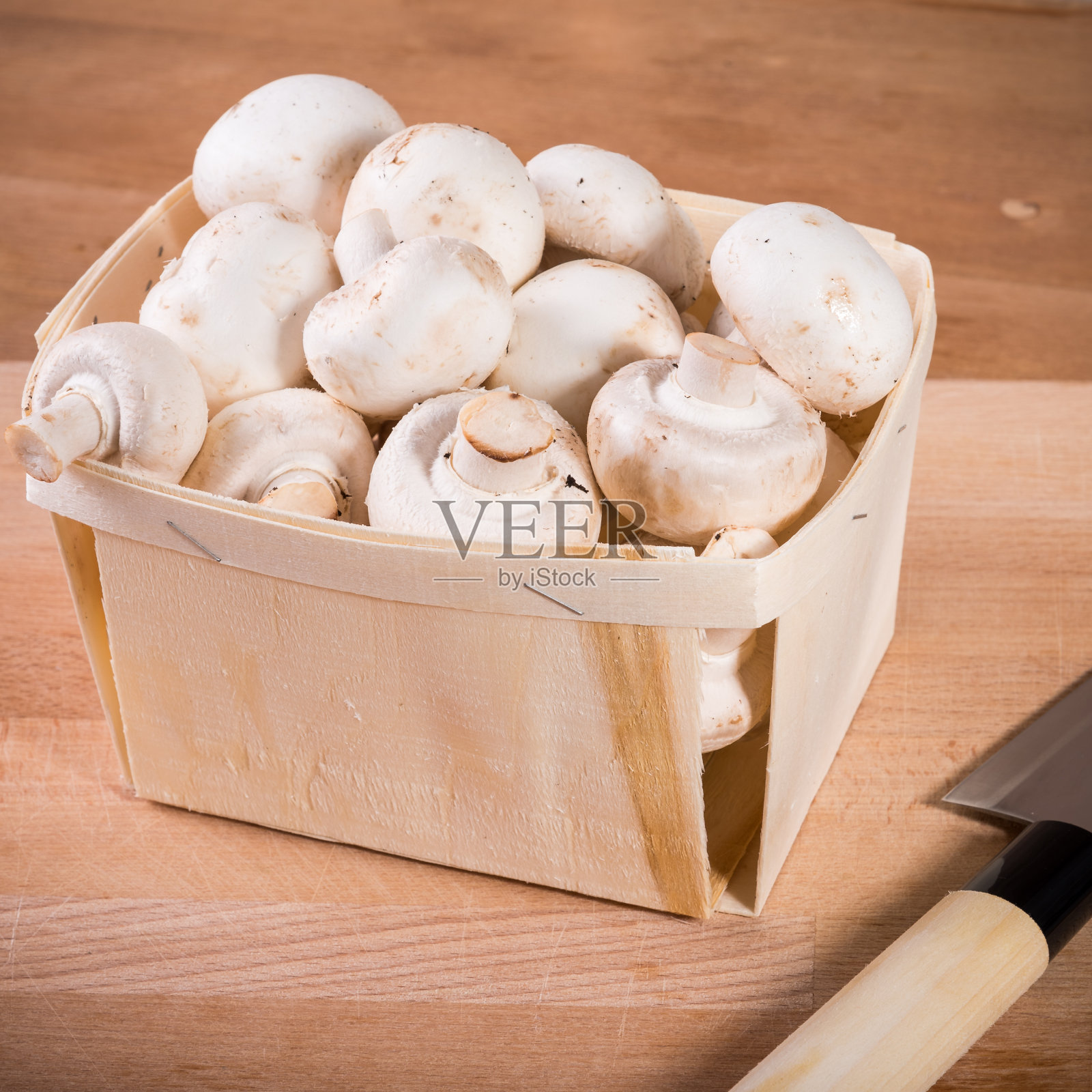 新鲜的香槟酒装在篮子里放在木砧板上用刀切,特写照片摄影图片