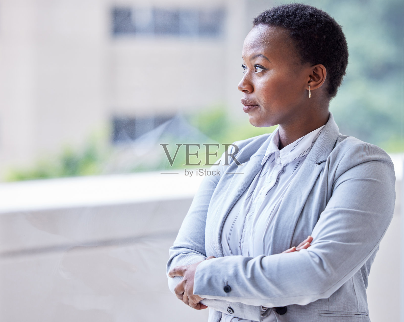 一个年轻的女商人往窗外看照片摄影图片