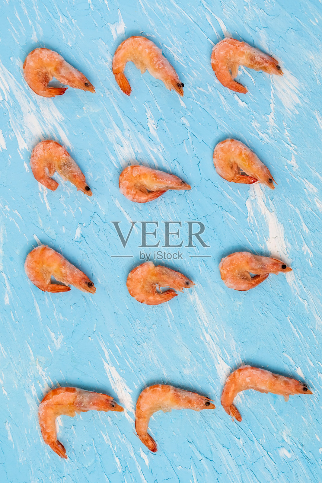 蓝色背景上的冻王虾。垂直图照片摄影图片