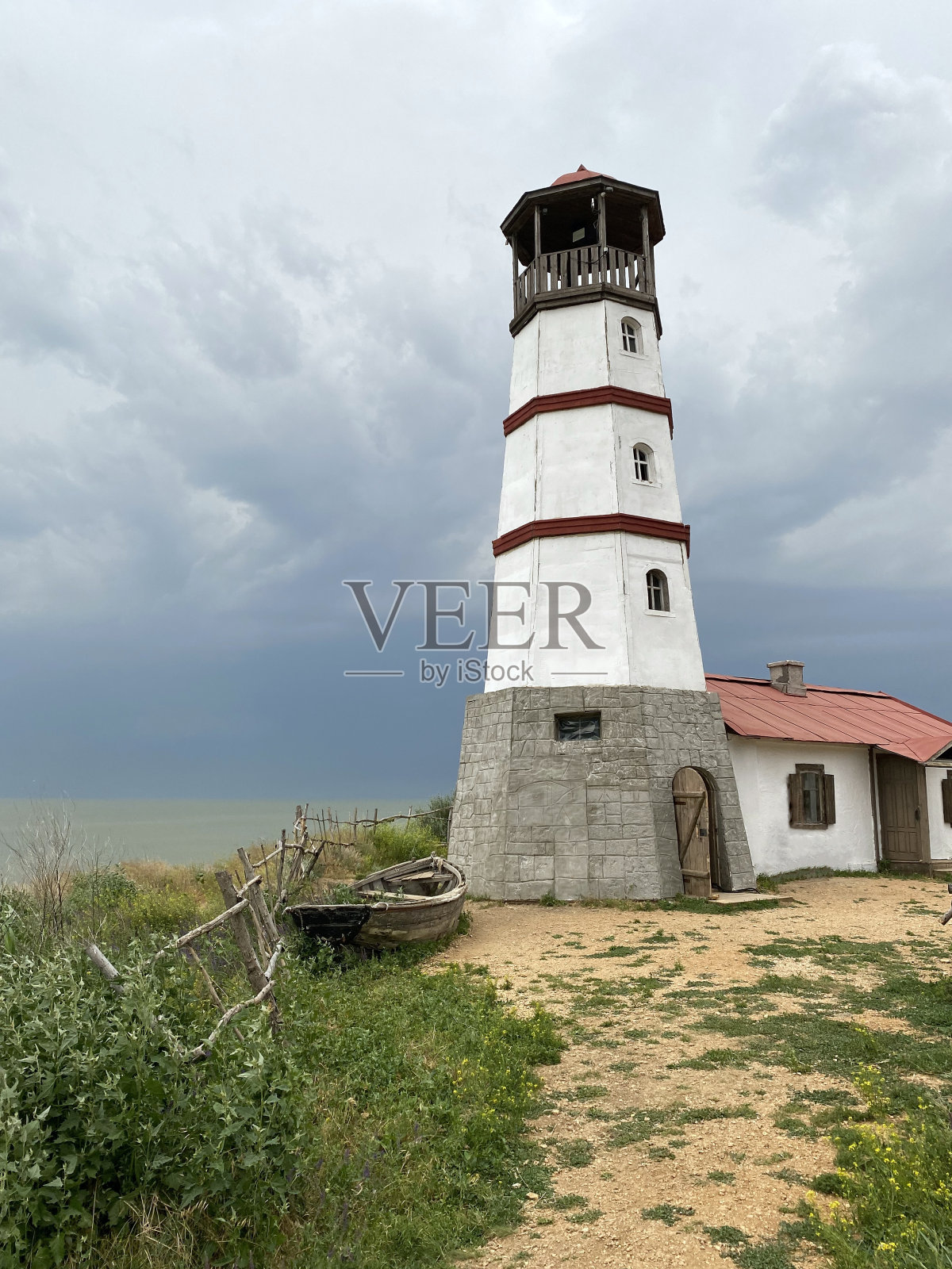 灯塔与绿色的草和多云的天空。照片摄影图片