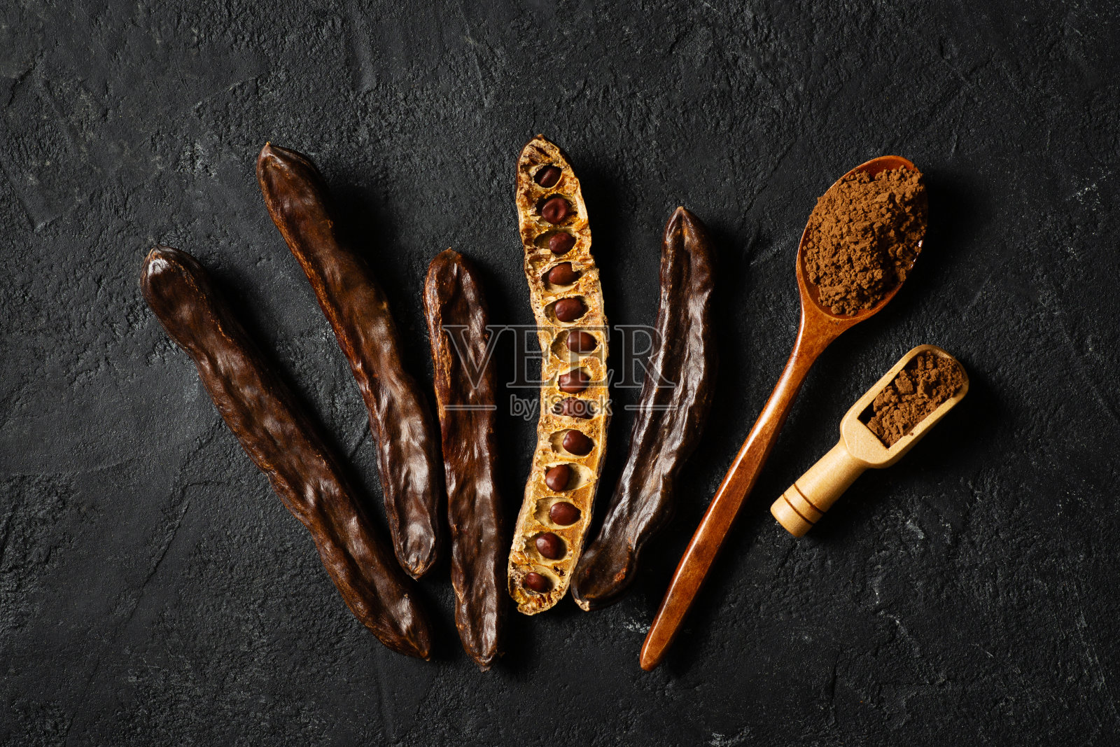 角豆和粉平铺在黑色的背景上照片摄影图片